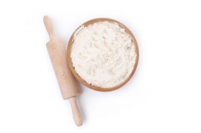 Rolling pin and bowl of flour isolated on white background